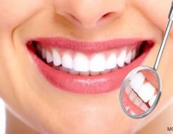 close up of white teeth examined by a dentist mirror