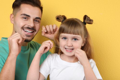 little girl and her father flossing teeth-img-blog