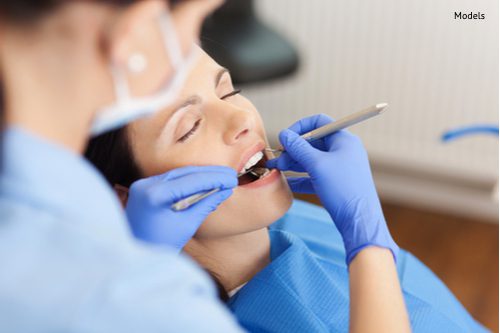 closeup of dentist examining mid adult patients mouth in clinic-img-blog