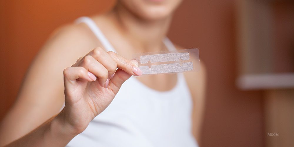 woman holding whitening strips