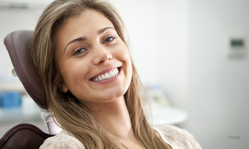 woman sitting in dentist chair and smiling