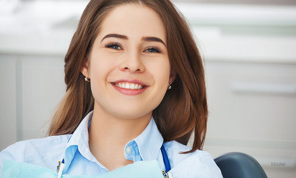 Woman with white teeth in a white chair